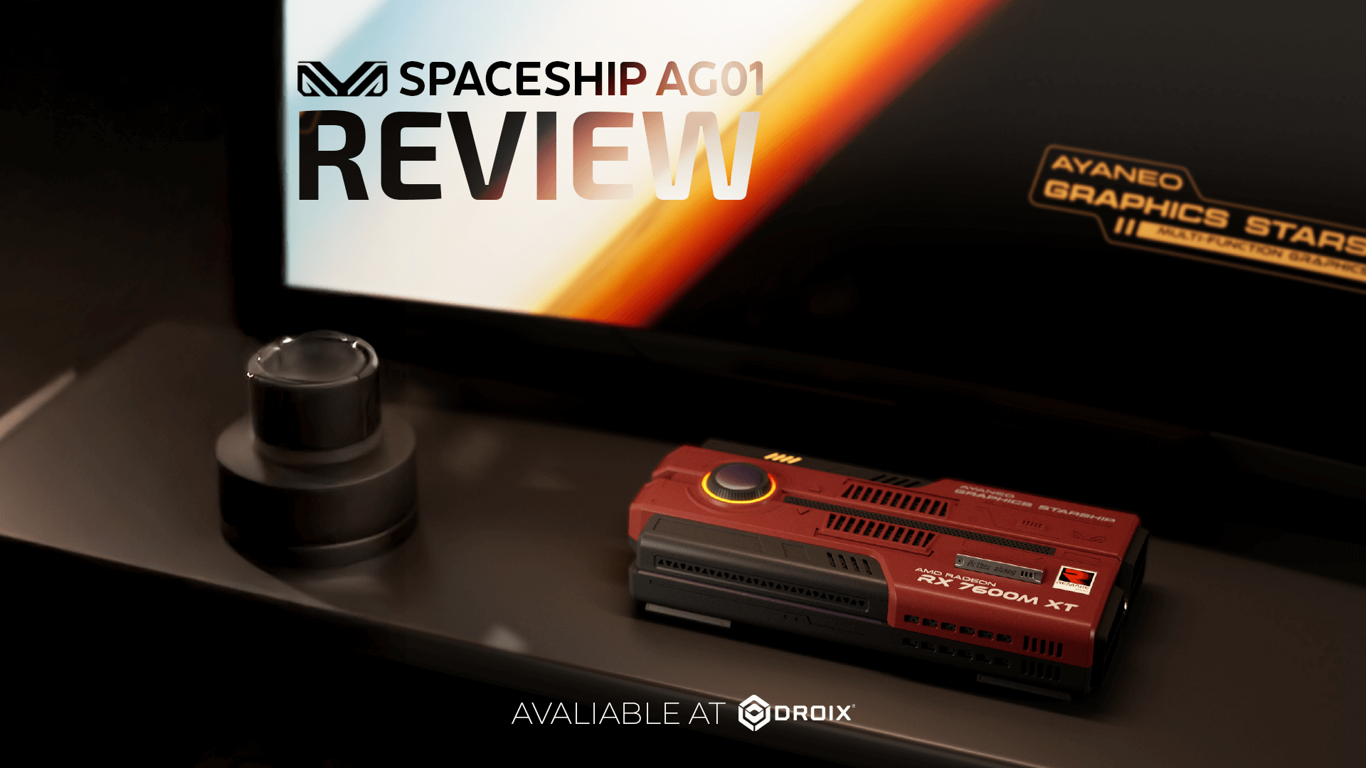 A product review image features a dark red rectangular device, possibly a graphics card or mini PC, with "RX 7600M XT" and "AYANEO GRAPHICS STARS" visible on it. In the background, a screen displays "SPACESHIP AG01 REVIEW" with a logo, and below the device, text reads "AVALIABLE AT DROIX." A small, dark, cylindrical object is to the left of the device.