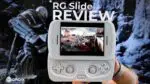 A first-person perspective image showing a pair of hands holding a white RG Slide handheld gaming console, centered in the frame. The console's screen displays an action-packed video game with multiple characters. In the background, a large monitor or screen shows a blurred image of a video game character, adding depth to the scene. Prominently overlaid in white text at the top are the words "RG Slide REVIEW". A black and white "DROIX" logo is visible in the bottom left corner.