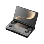 AYN-THOR-BLACK-LISTING-DONE-01 An angled, open view of a light grey AYN Thor handheld gaming console with a clamshell design, against a dark, featureless background. The top screen is open, displaying a soft golden abstract image. The bottom half of the device shows the controls, including a black D-pad, black analog sticks, and face buttons in red, blue, green, and yellow, resembling the classic "black" controller aesthetic. Both the top and bottom screens are reflective, mirroring the golden light.