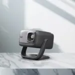 RockTek PJ500 Ultra 1080p projector in dark gray, front angle on stand, textured face and glass lens